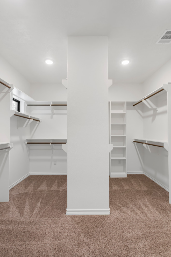 На фото: гардеробная комната унисекс в классическом стиле с белыми фасадами и ковровым покрытием с