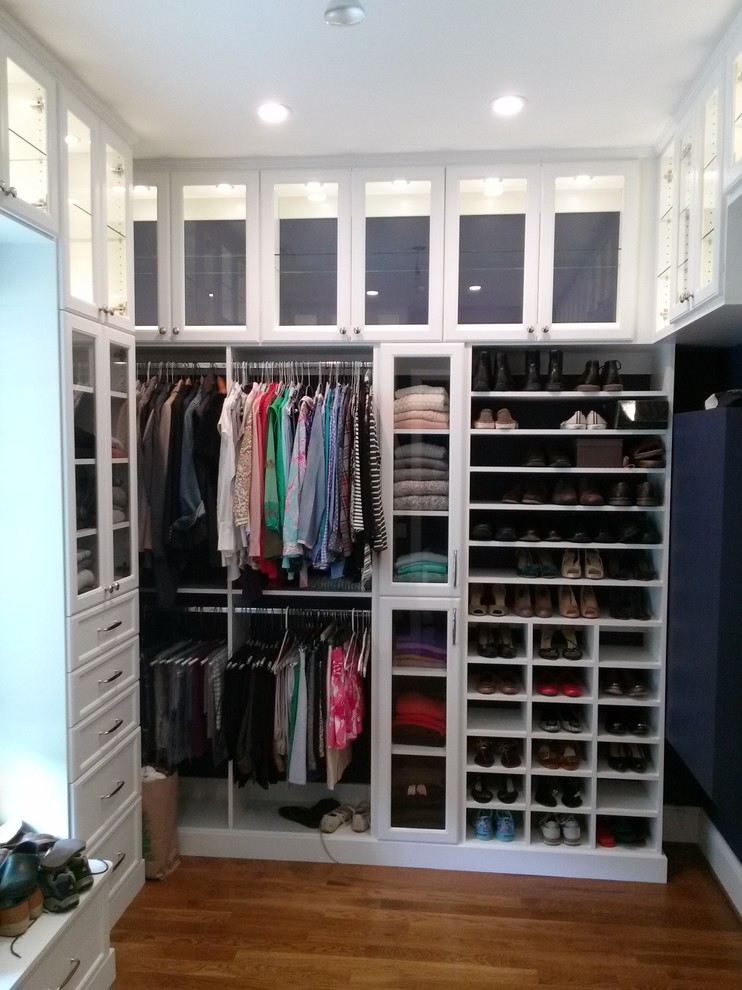 Foto de vestidor unisex tradicional grande con armarios con rebordes decorativos, puertas de armario blancas y suelo de madera en tonos medios