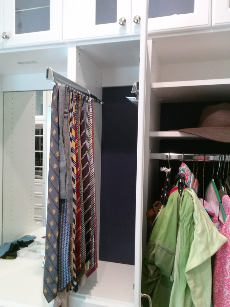 Ejemplo de vestidor unisex clásico grande con armarios con rebordes decorativos, puertas de armario blancas y suelo de madera en tonos medios