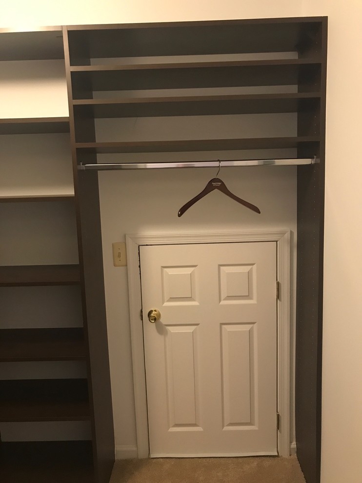 Ejemplo de armario vestidor unisex contemporáneo de tamaño medio con armarios con paneles lisos, puertas de armario de madera en tonos medios, moqueta y suelo beige