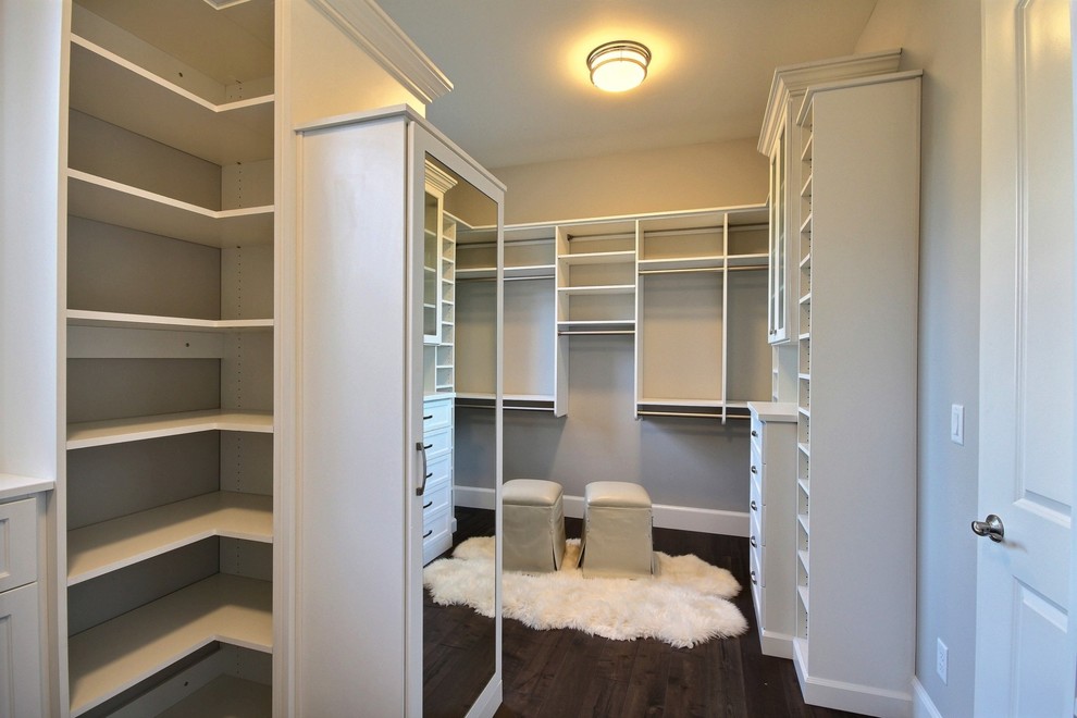 Imagen de armario vestidor unisex clásico renovado extra grande con armarios con paneles empotrados, puertas de armario blancas y suelo de madera oscura
