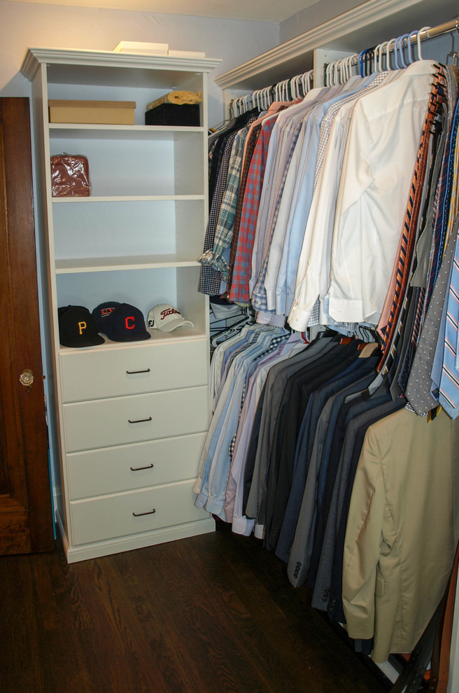 Foto de armario vestidor unisex clásico de tamaño medio con armarios con paneles lisos, puertas de armario blancas y suelo de madera oscura