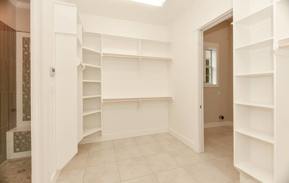 Ejemplo de armario vestidor unisex de estilo americano de tamaño medio con armarios abiertos, puertas de armario blancas, suelo de baldosas de cerámica y suelo beige