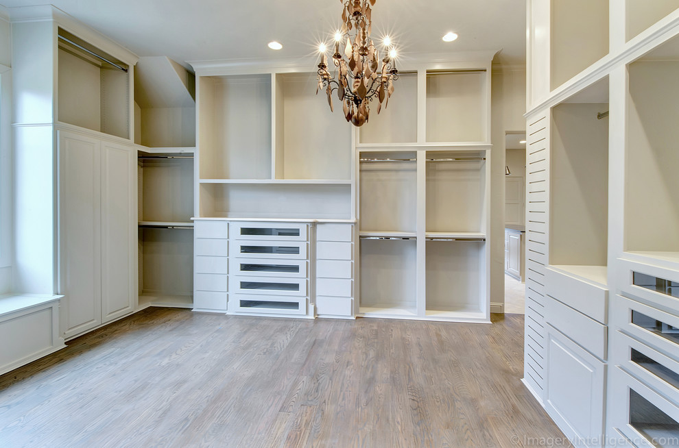 Exemple d'un dressing room méditerranéen avec des portes de placard blanches et un sol en bois brun.