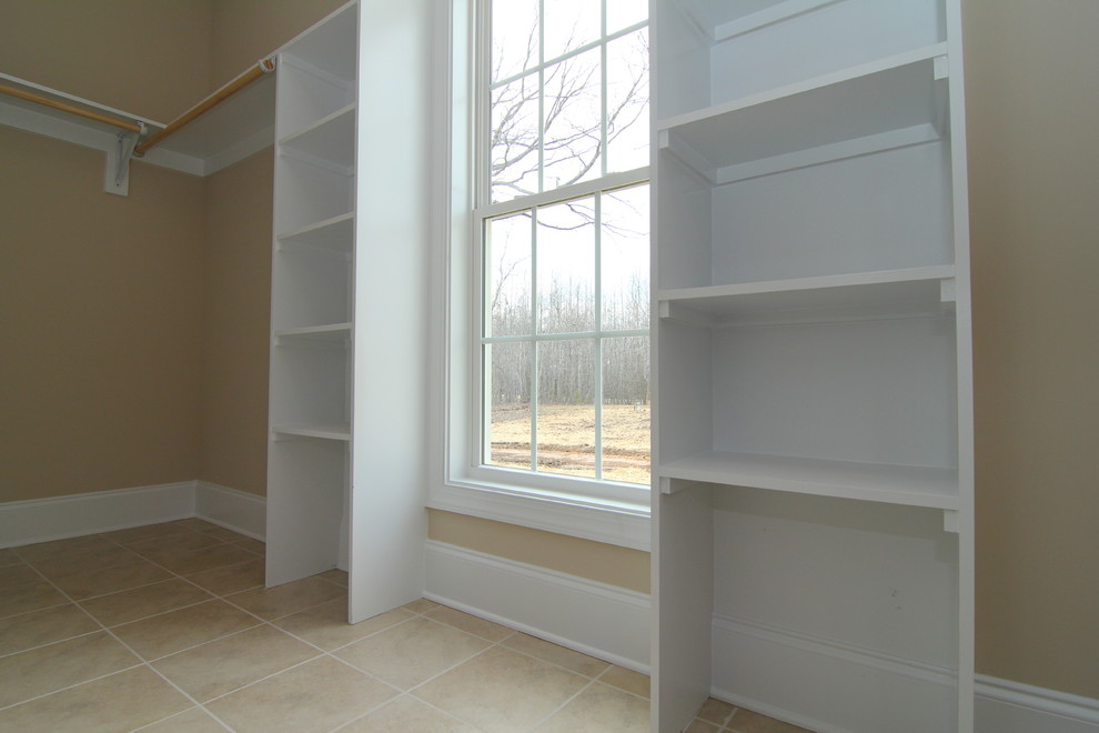 Example of a mid-sized classic gender-neutral ceramic tile walk-in closet design in Raleigh with open cabinets