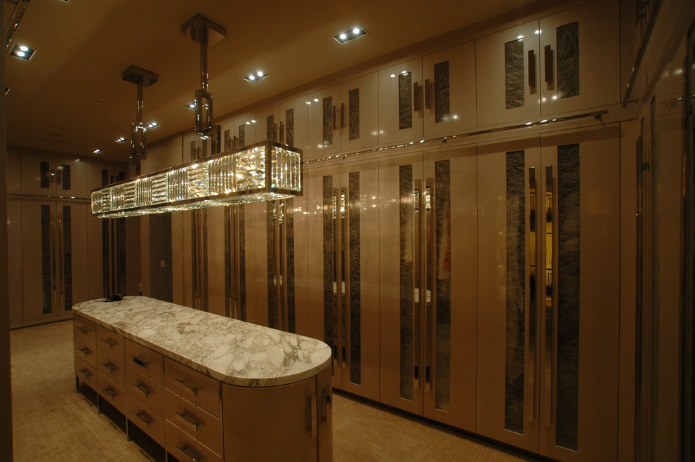 Ejemplo de armario vestidor de mujer clásico renovado grande con armarios con paneles lisos, puertas de armario beige y moqueta