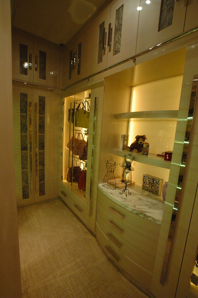 Aménagement d'un grand dressing classique pour une femme avec un placard à porte plane, des portes de placard beiges et moquette.