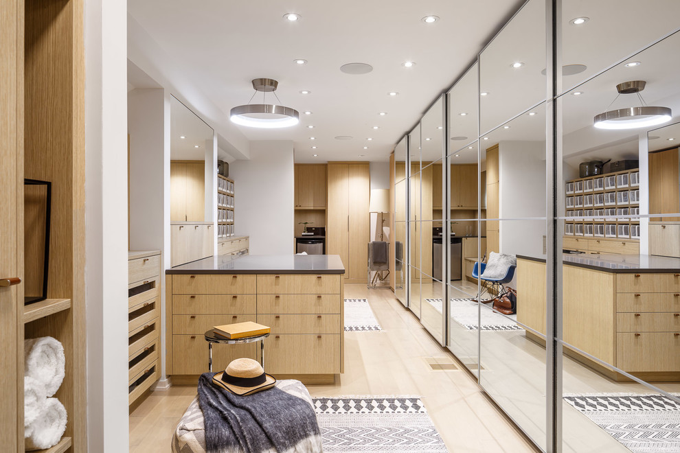 Стильный дизайн: большая гардеробная комната унисекс в стиле модернизм с плоскими фасадами, светлыми деревянными фасадами, светлым паркетным полом и бежевым полом - последний тренд