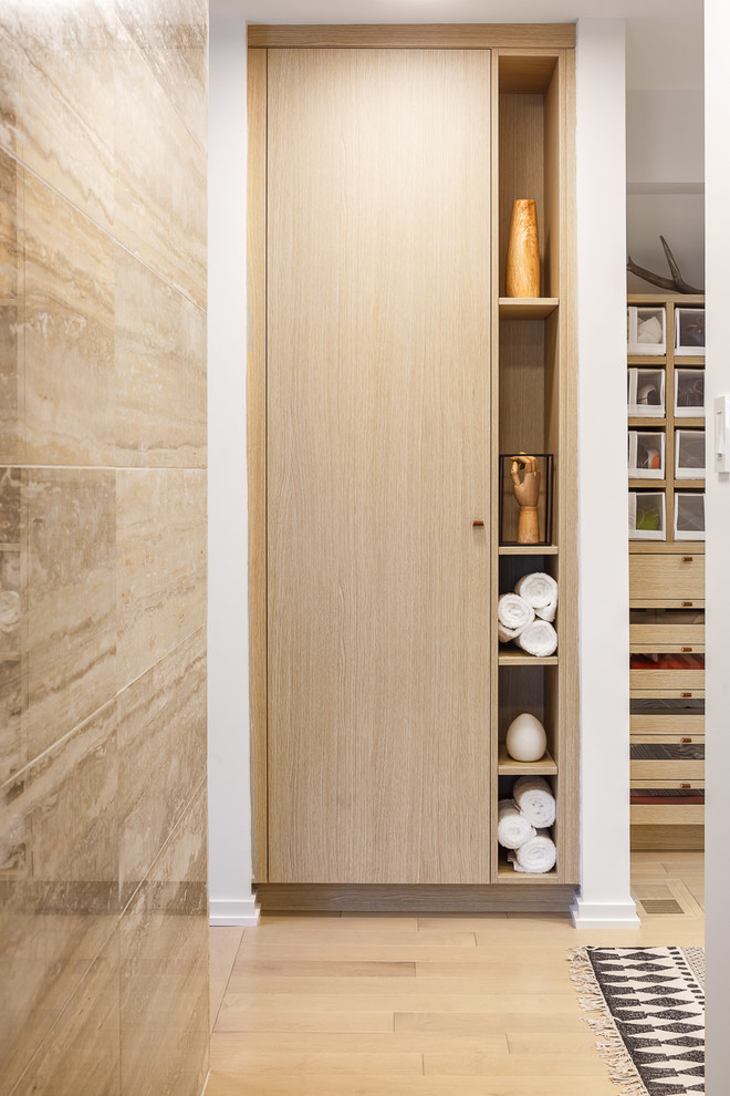Walk-in closet - large modern gender-neutral light wood floor walk-in closet idea in Toronto with flat-panel cabinets and light wood cabinets