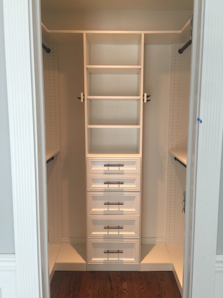 Mid-sized elegant gender-neutral dark wood floor and brown floor walk-in closet photo in New York with recessed-panel cabinets