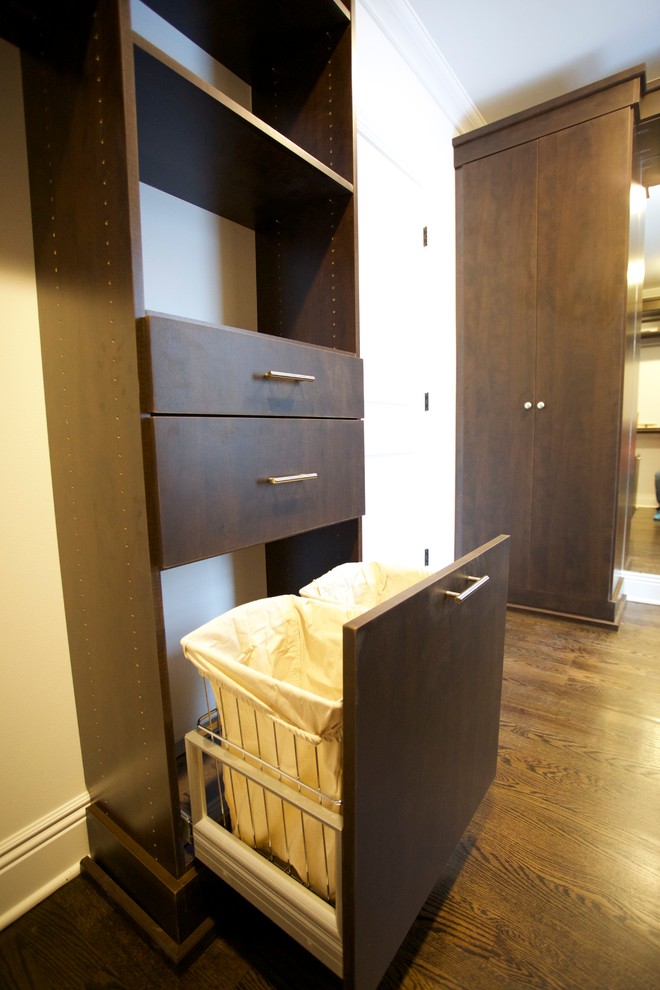 Diseño de armario vestidor de hombre minimalista con armarios con paneles lisos, puertas de armario de madera en tonos medios, suelo de madera oscura y suelo marrón