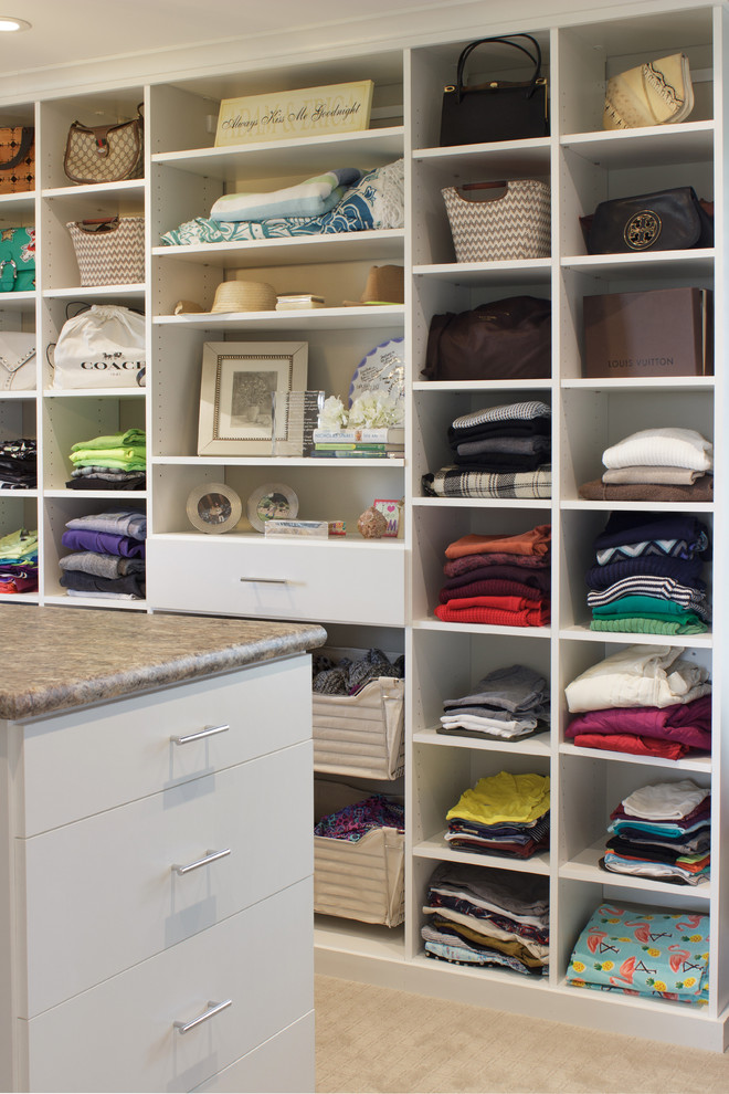 Ejemplo de armario vestidor unisex clásico renovado grande con armarios con paneles lisos, puertas de armario blancas, moqueta y suelo beige