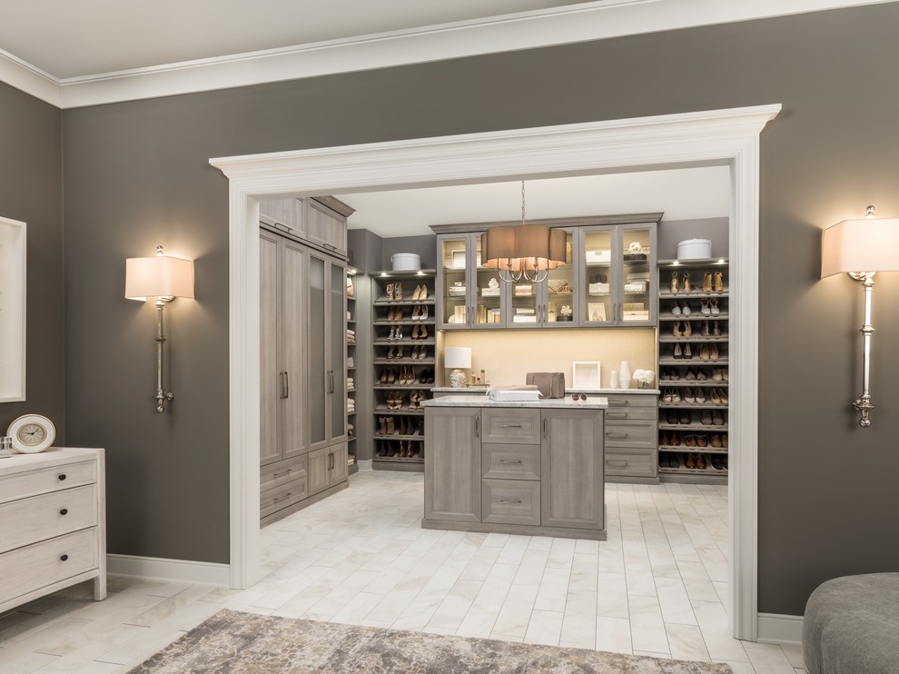 Expansive modern gender neutral walk-in wardrobe in Chicago with shaker cabinets, beige floors and grey cabinets.