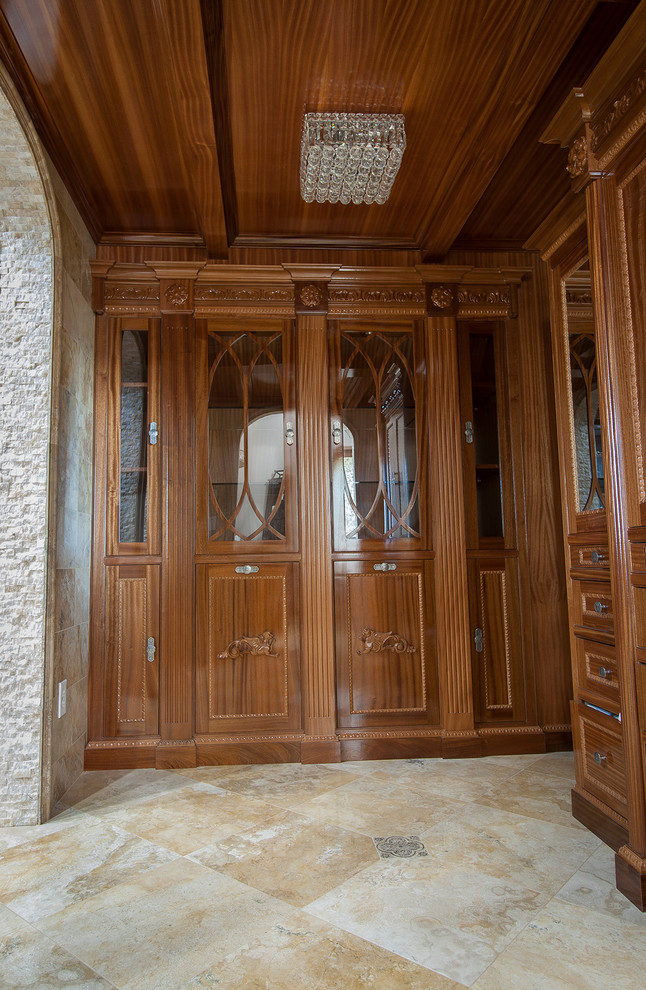 Идея дизайна: большая гардеробная комната унисекс в классическом стиле с фасадами цвета дерева среднего тона и полом из травертина