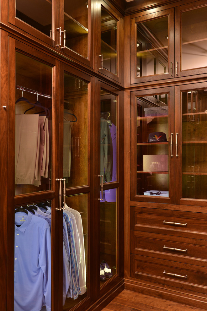 Exempel på ett stort klassiskt omklädningsrum för män, med luckor med glaspanel, skåp i mellenmörkt trä och mörkt trägolv