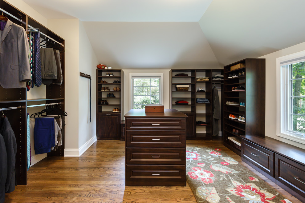 Dressing room - large traditional men's medium tone wood floor and brown floor dressing room idea in New York with raised-panel cabinets and dark wood cabinets