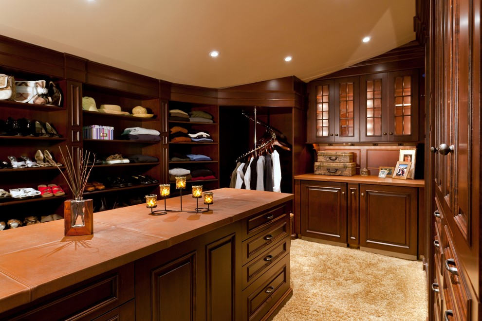 Inspiration for a huge timeless gender-neutral carpeted dressing room remodel in Boston with raised-panel cabinets and dark wood cabinets