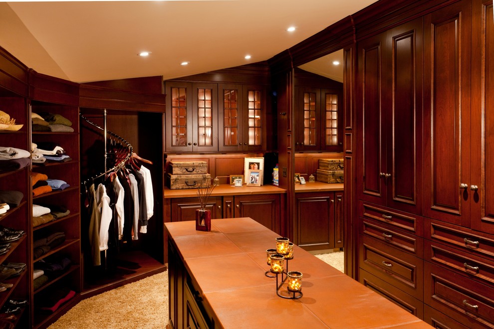 Idées déco pour un très grand dressing room classique en bois foncé neutre avec un placard avec porte à panneau surélevé et moquette.