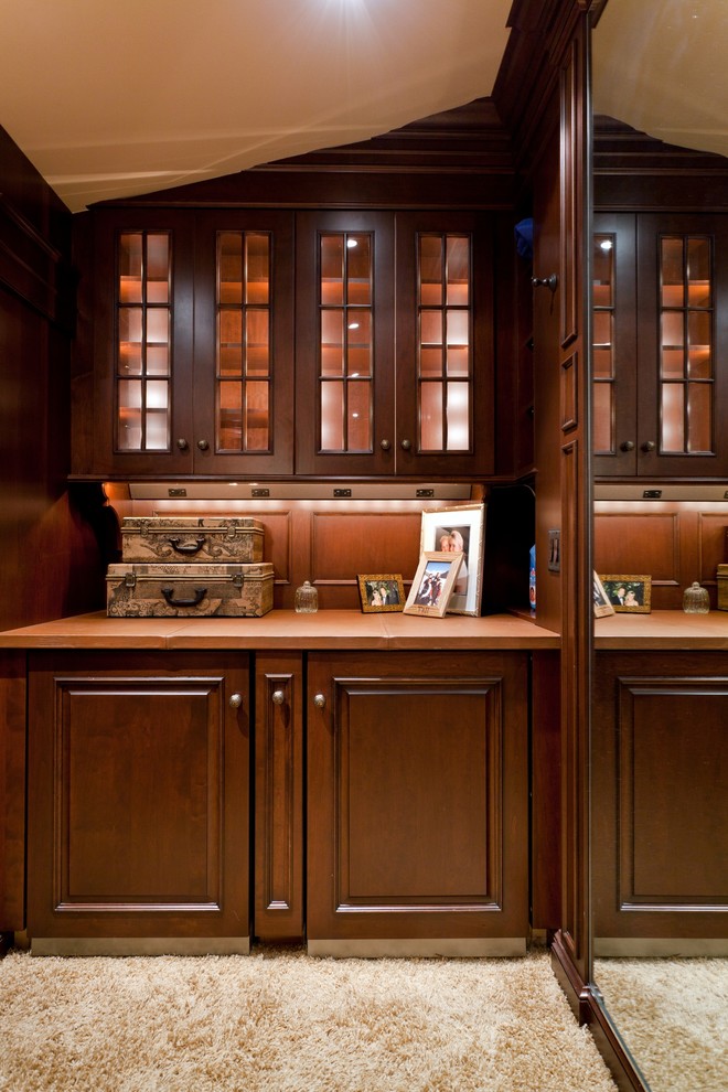 Ejemplo de vestidor unisex clásico extra grande con armarios con paneles con relieve, puertas de armario de madera en tonos medios y moqueta