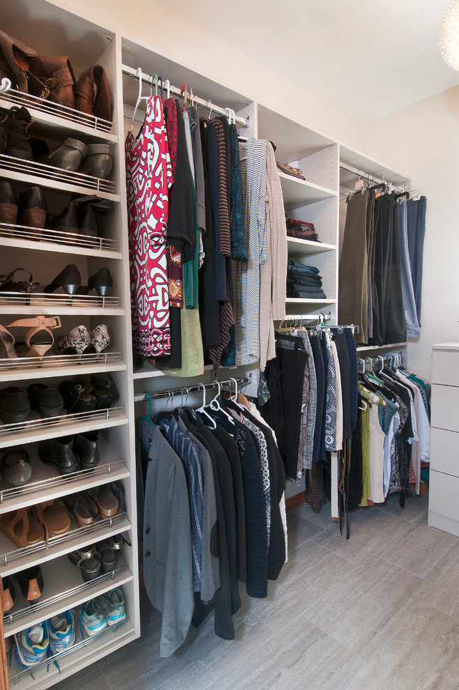 This is an example of a small modern gender neutral walk-in wardrobe in Wichita with flat-panel cabinets, white cabinets and ceramic flooring.