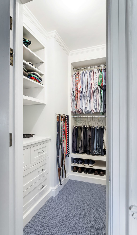 This is an example of a small classic walk-in wardrobe for women in Detroit with recessed-panel cabinets, white cabinets, carpet and blue floors.