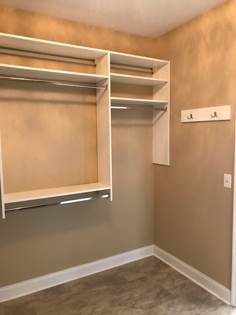 Inspiration for a medium sized traditional gender neutral walk-in wardrobe in Other with flat-panel cabinets, white cabinets, lino flooring and beige floors.