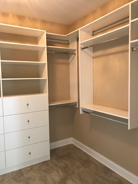 Walk-in closet - mid-sized traditional gender-neutral linoleum floor and beige floor walk-in closet idea in Other with flat-panel cabinets and white cabinets