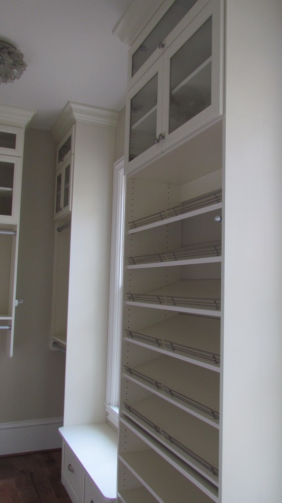 Exempel på ett mellanstort klassiskt walk-in-closet för könsneutrala, med luckor med glaspanel, vita skåp och mellanmörkt trägolv