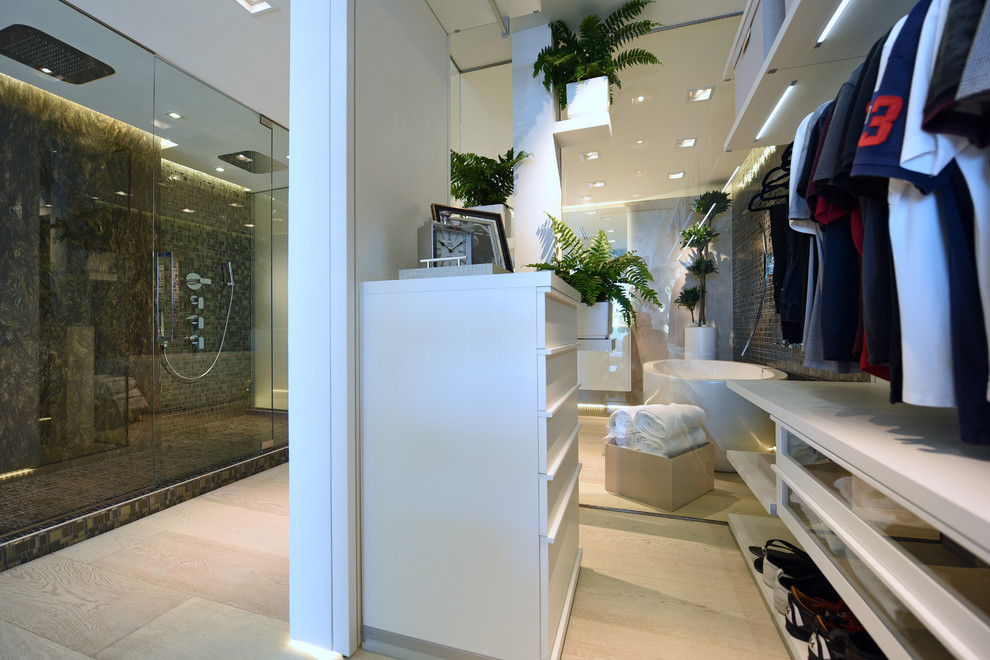 Ispirazione per un grande spazio per vestirsi per uomo minimalista con parquet chiaro