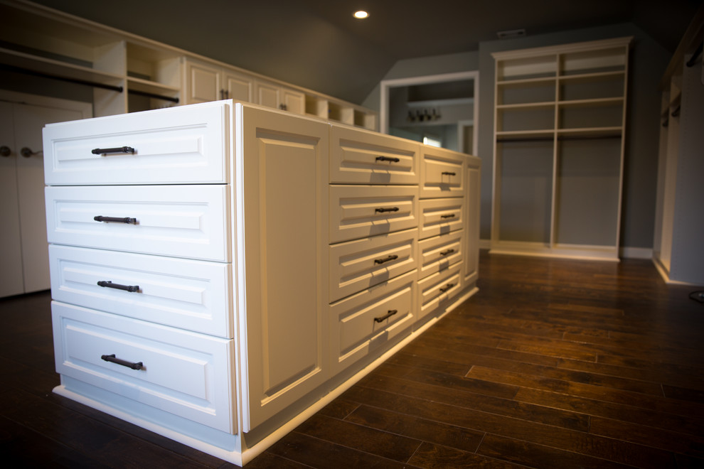 Design ideas for a large classic gender neutral walk-in wardrobe in Atlanta with raised-panel cabinets, white cabinets, medium hardwood flooring and brown floors.