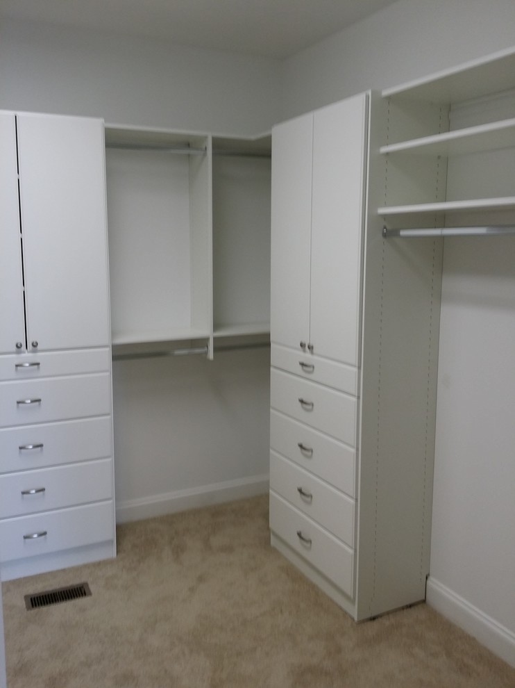Imagen de armario y vestidor unisex tradicional de tamaño medio con armarios con paneles lisos, puertas de armario blancas y moqueta