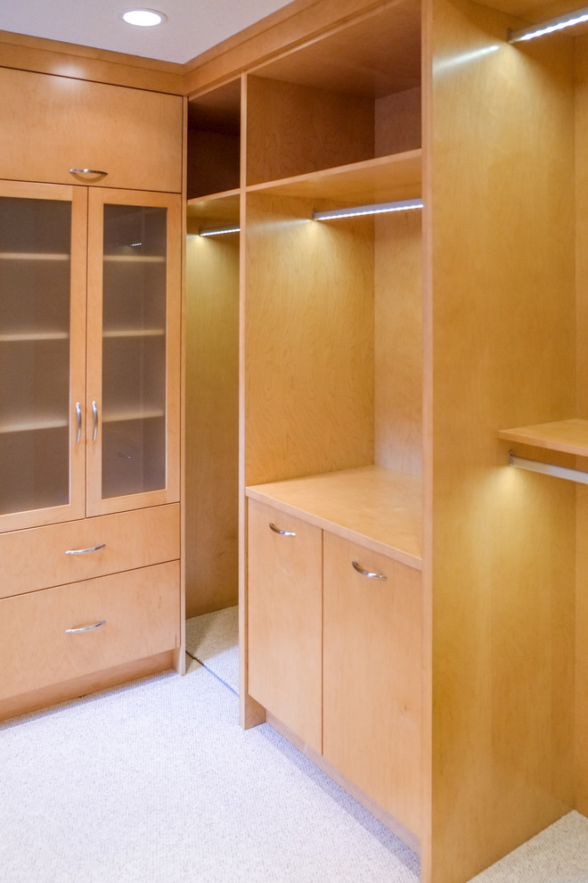 Esempio di una cabina armadio unisex minimal di medie dimensioni con ante lisce, ante in legno chiaro e moquette