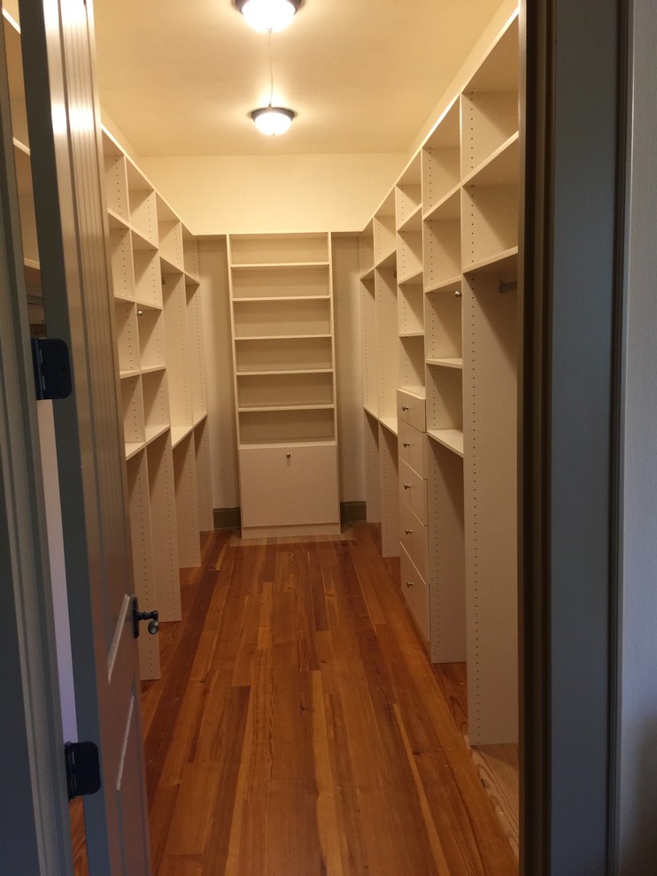 Idéer för att renovera ett stort vintage walk-in-closet för könsneutrala, med släta luckor, vita skåp, mellanmörkt trägolv och brunt golv