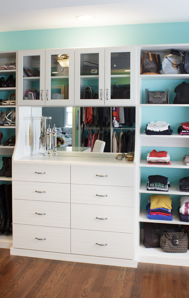 Inspiration for a large traditional dressing room for women in New York with flat-panel cabinets, white cabinets and medium hardwood flooring.