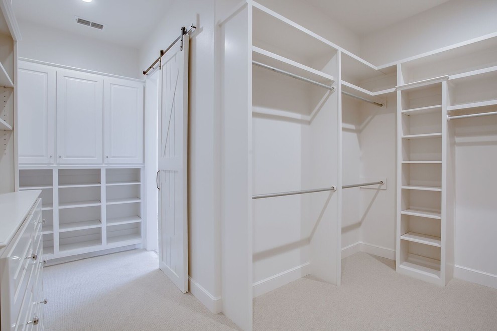 Imagen de armario vestidor unisex clásico renovado grande con armarios con paneles con relieve, puertas de armario blancas, moqueta y suelo beige