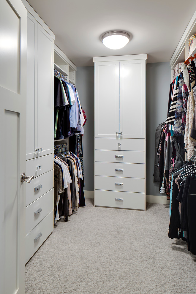 Diseño de armario vestidor unisex clásico grande con armarios con paneles lisos, puertas de armario blancas y moqueta