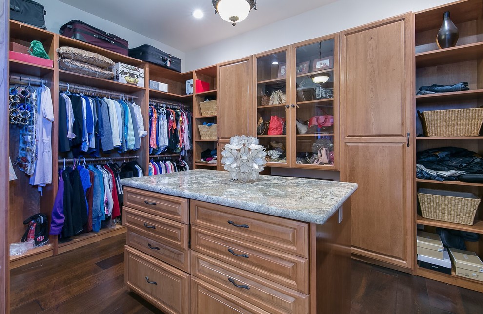 This is an example of a medium sized mediterranean gender neutral walk-in wardrobe in San Francisco with open cabinets, light wood cabinets and dark hardwood flooring.