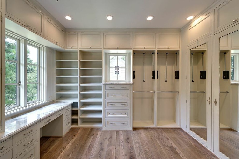 Large elegant women's medium tone wood floor walk-in closet photo in Houston with gray cabinets