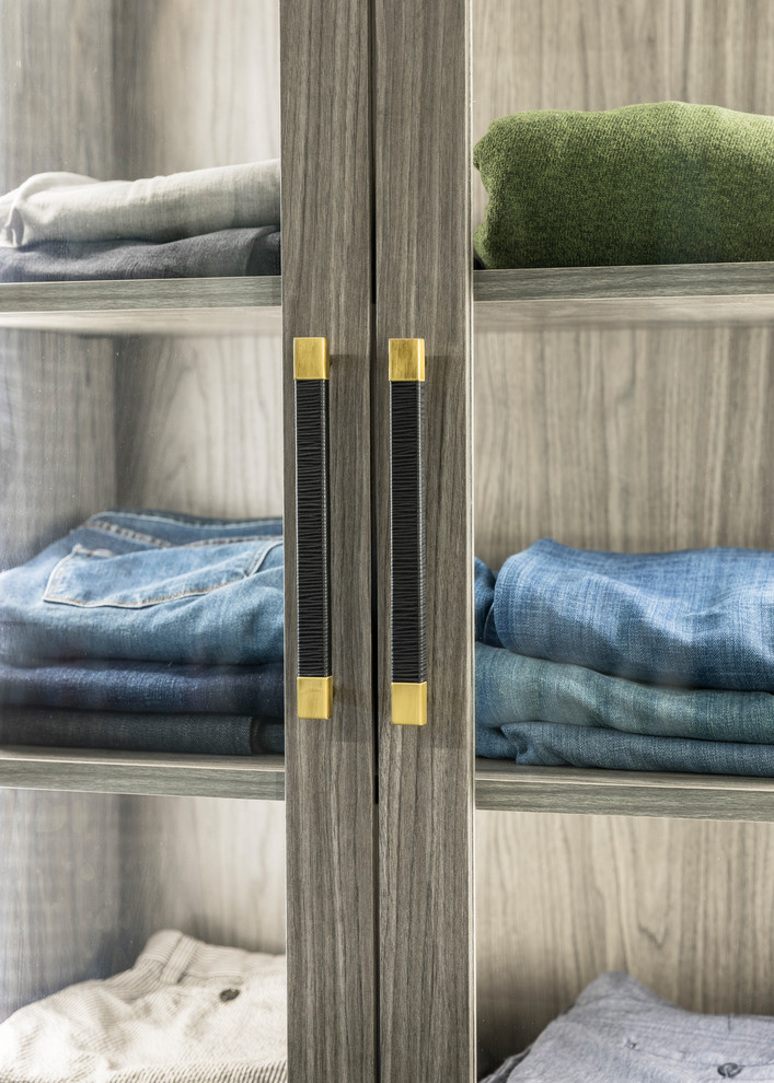 Diseño de armario vestidor de hombre moderno grande con armarios con paneles lisos, puertas de armario grises, moqueta y suelo azul