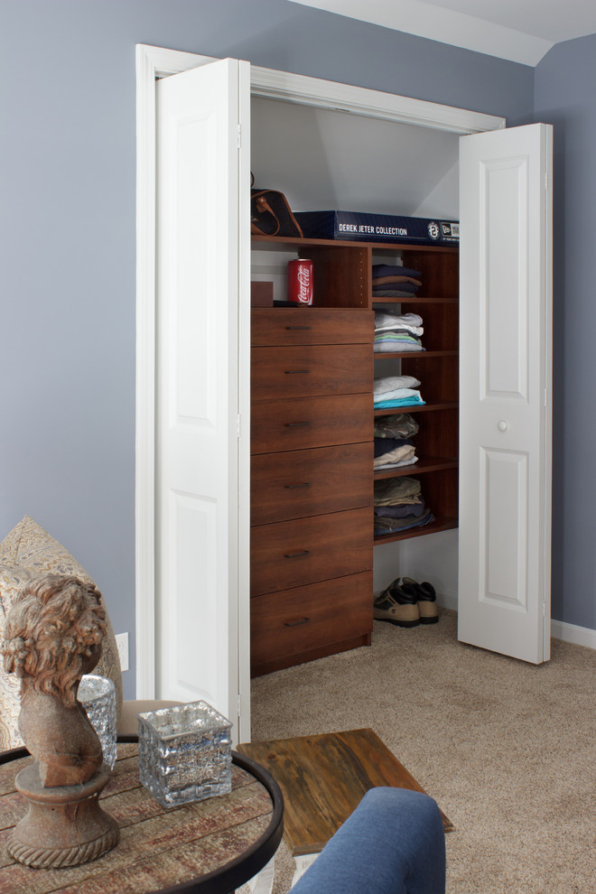 Foto de armario de hombre contemporáneo pequeño con armarios con paneles lisos, puertas de armario de madera en tonos medios y moqueta