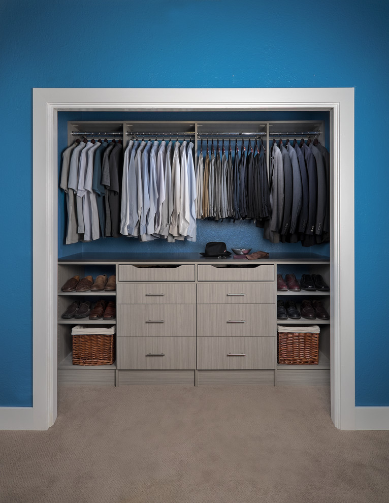 Foto de armario de hombre actual de tamaño medio con armarios con paneles lisos, puertas de armario de madera clara, moqueta y suelo beige