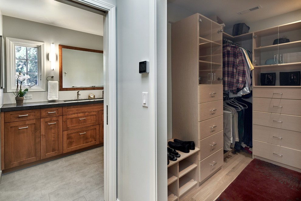 Ejemplo de armario vestidor clásico renovado de tamaño medio con armarios estilo shaker, puertas de armario de madera oscura y suelo de madera clara