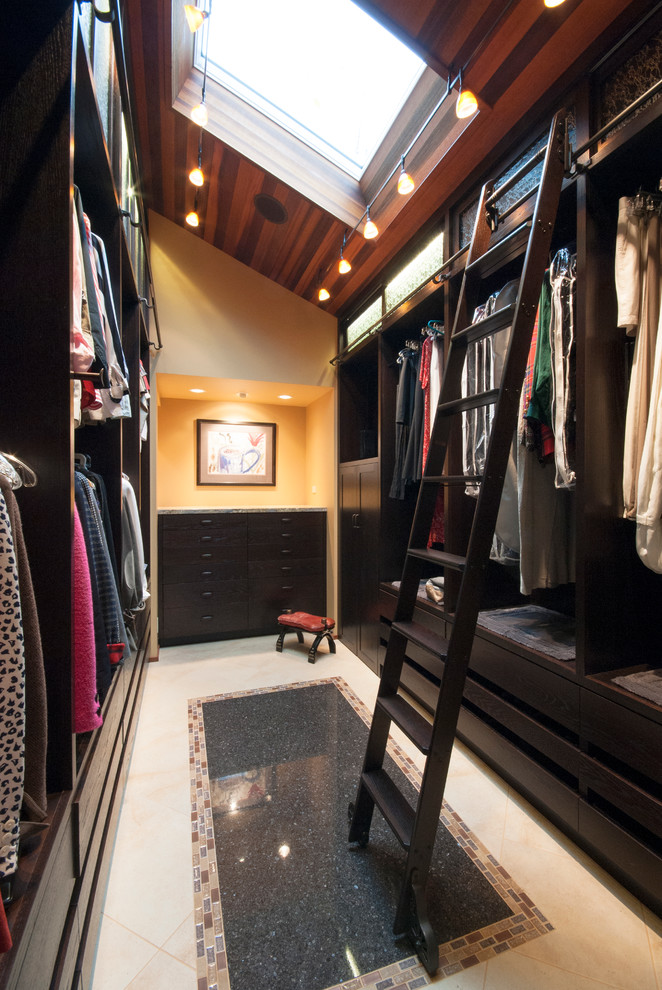 Foto de armario vestidor unisex actual con puertas de armario de madera en tonos medios y suelo de travertino