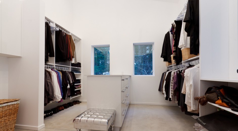 This is an example of a large contemporary gender neutral walk-in wardrobe in Vancouver with flat-panel cabinets and white cabinets.