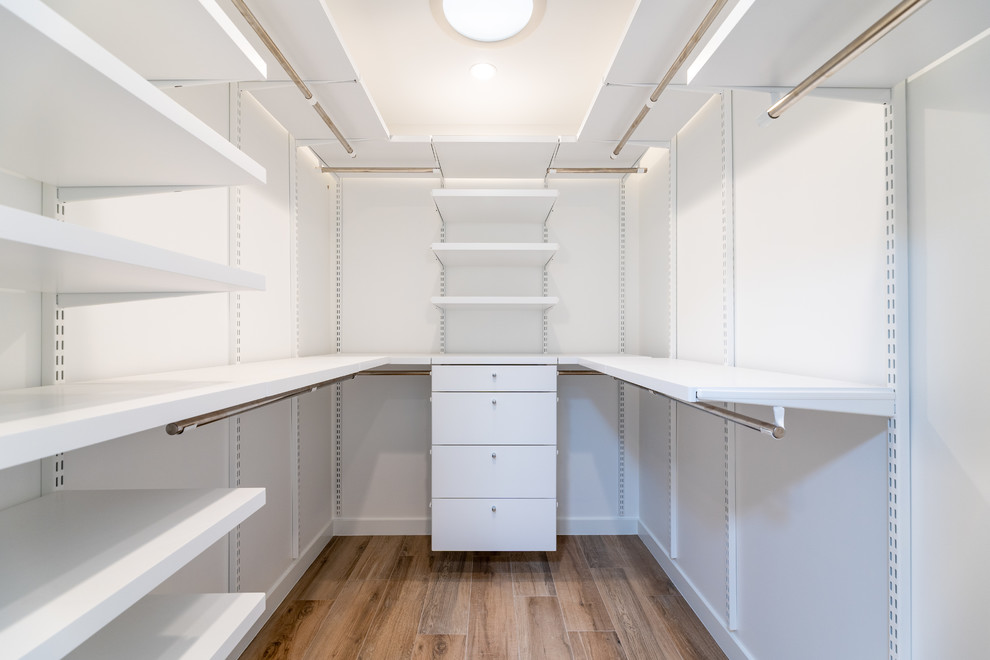 Diseño de armario vestidor unisex tradicional renovado grande con puertas de armario blancas y suelo de baldosas de porcelana