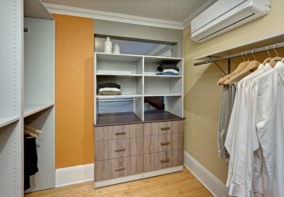 Imagen de armario y vestidor actual con suelo de madera en tonos medios