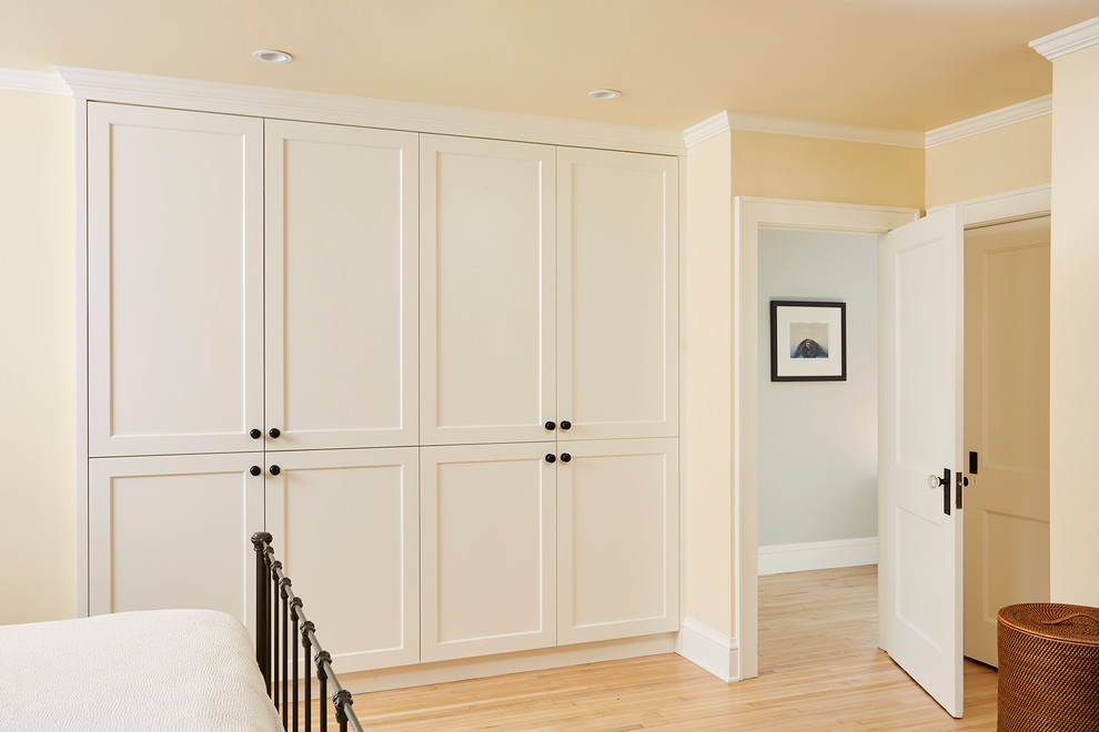 Стильный дизайн: шкаф в нише среднего размера, унисекс в классическом стиле с фасадами с утопленной филенкой, белыми фасадами и светлым паркетным полом - последний тренд