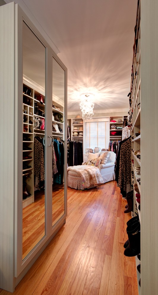 Inspiration for a large timeless women's light wood floor and beige floor walk-in closet remodel in Other with recessed-panel cabinets and light wood cabinets