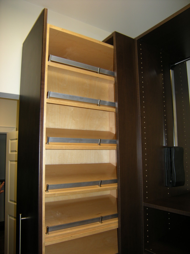 Example of a small classic gender-neutral dark wood floor dressing room design in Charlotte with flat-panel cabinets and dark wood cabinets