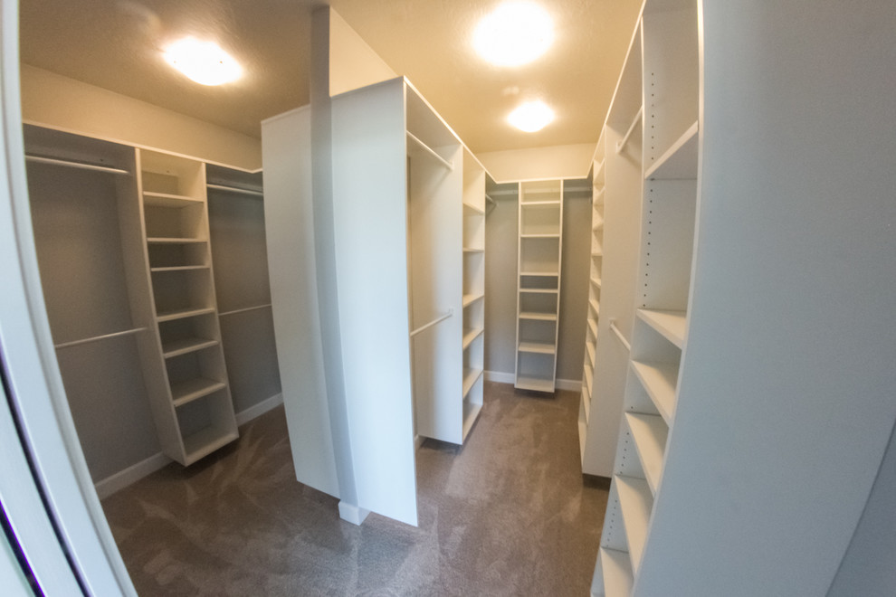 Photo of a small classic gender neutral walk-in wardrobe in Other with white cabinets and carpet.